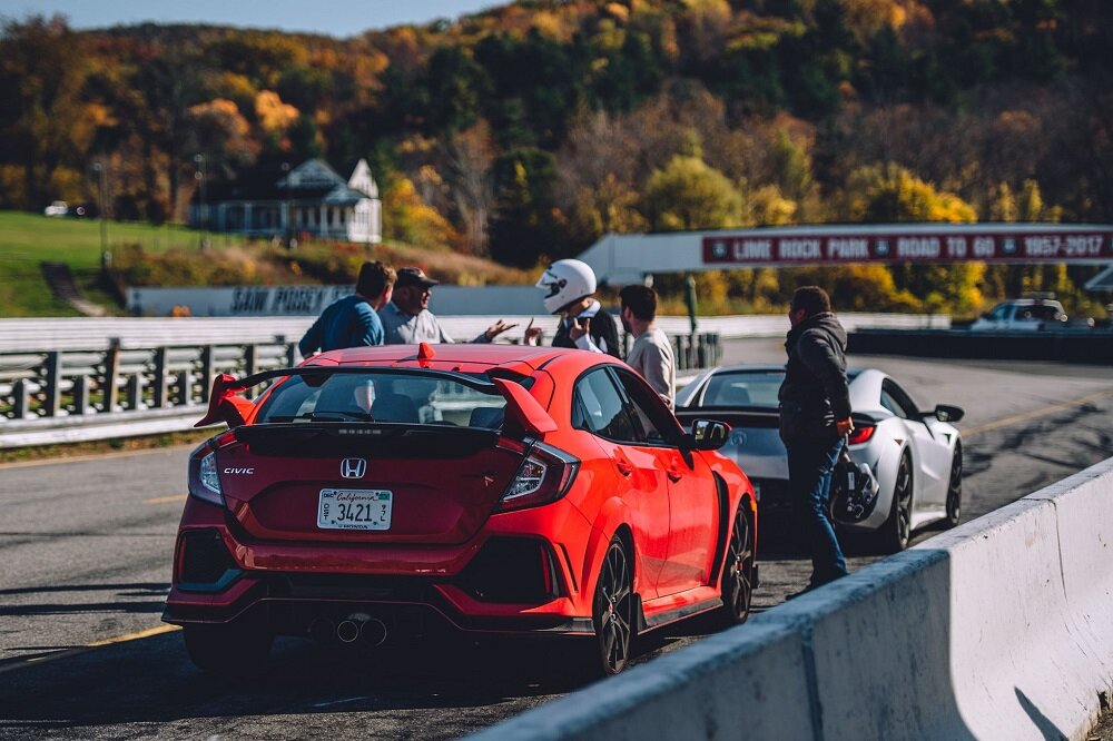 Drivers of Red Civic Type R FK8 and Acura NSX listening to coach at Lime Rock Park Track Day